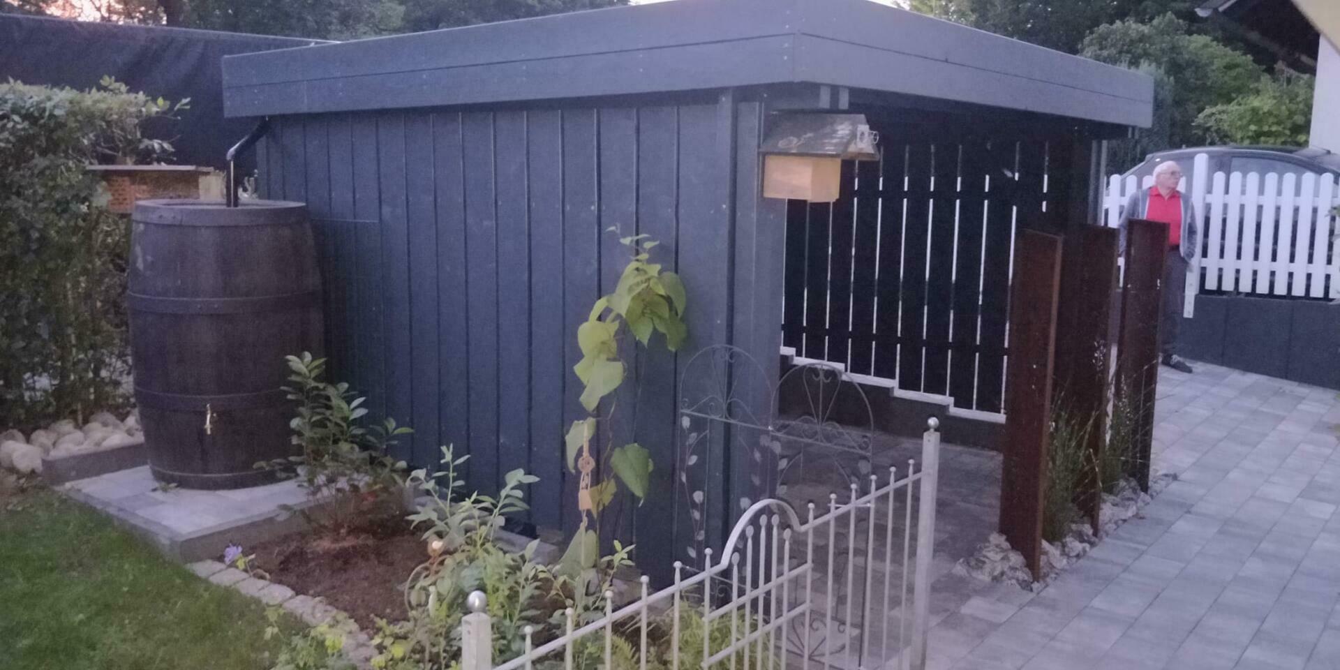 Valencia Carport, eingekürzt, drei Seiten Deckelschalung, Holzblende in RAL 7016. Als Holz-Schuppen genutzt