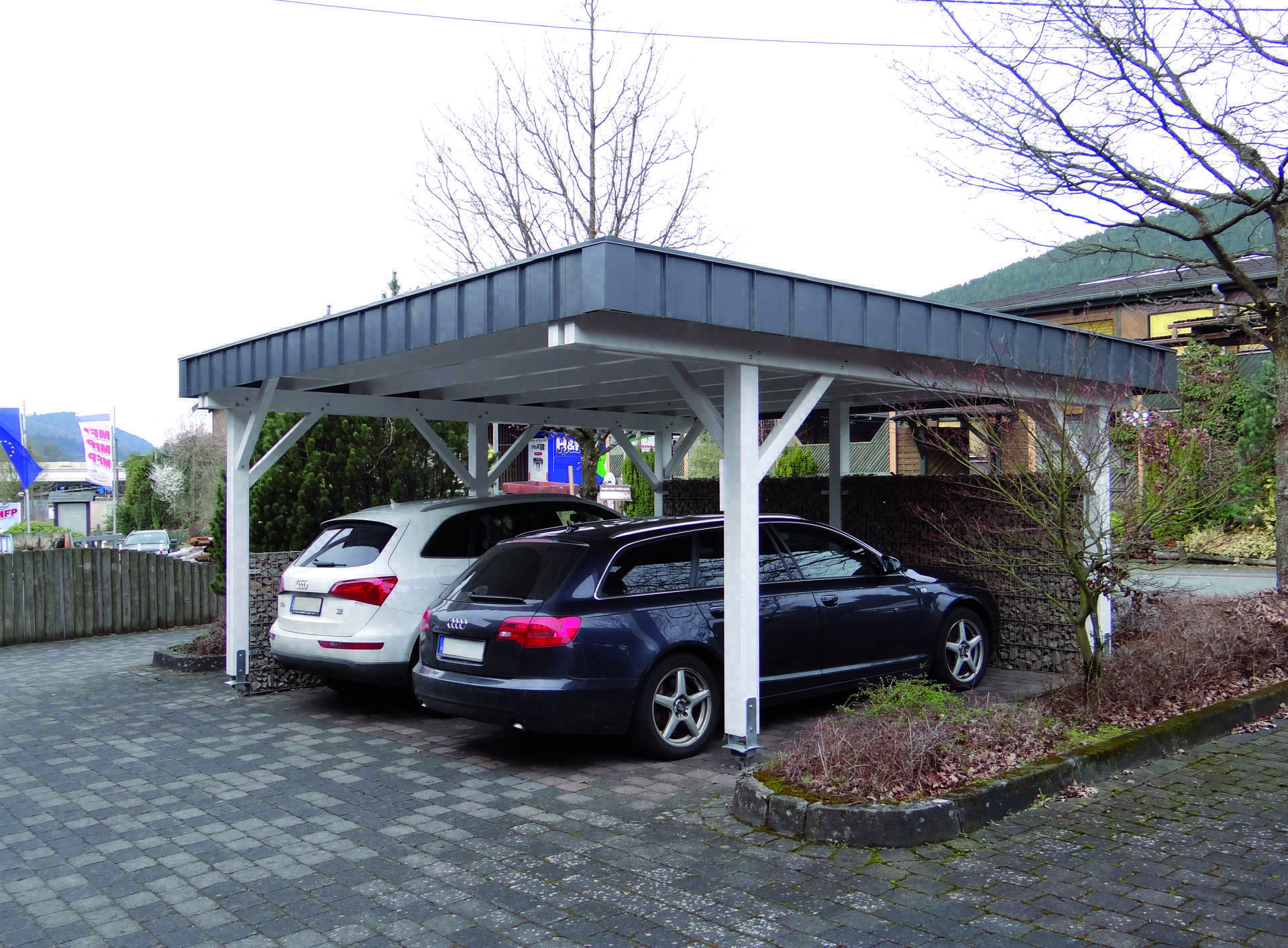 Singapur Doppelcarport, normale Ausführung, weiß, mit Attika-Blende und Gabionenmauer (vom Kunden)